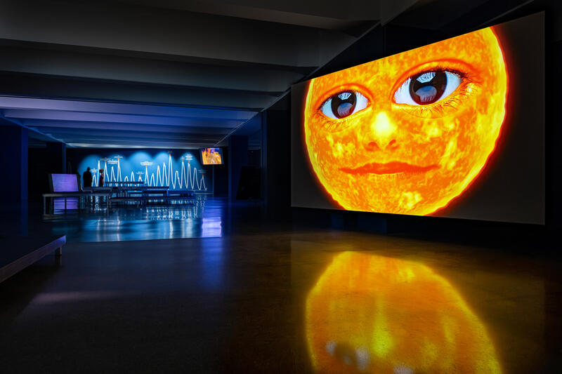s:128:"Agnieszka Polskas Videoinstallation "The New Sun" leitet die Besucher durch das "U" zu den unterschiedlichen Ausstellungsebenen.";