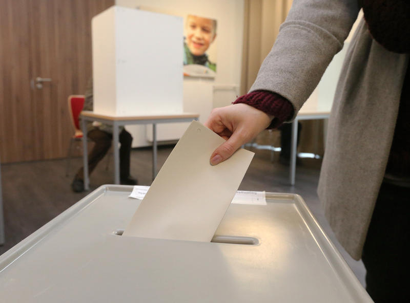 s:124:"Eine Frau gibt am 13.03.2016 in einem Wahllokal in Halle an der Saale bei der Landtagswahl in Sachsen-Anhalt ihre Stimme ab.";