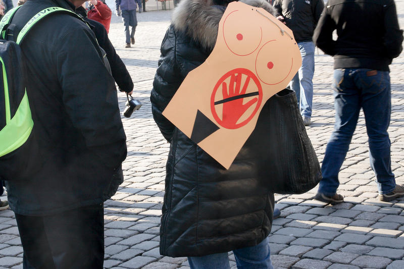 s:67:"Eine Frau protestiert mit einem Plakat gegen sexuelle Belästigung.";