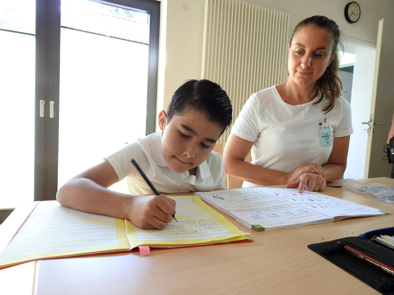 s:118:"Der Zweitklässler Zuhair kommt regelmäßig zum Nachhilfe-Treff der Flüchtlingsinitiative „Willkommen im Dorf“. ";