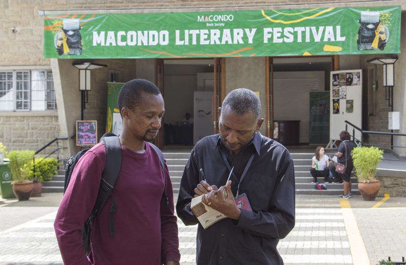 s:104:"Der kenianische Autor Peter Kimani beim Signieren eines Buches beim Macondo Literary Festival in Nairobi";