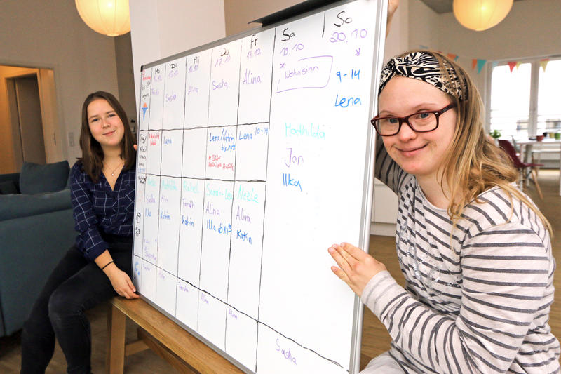 s:103:"Alina Düring (li.) und Neele Buchholz an der Planungstafel ihrer inklusiven Wohngemeinschaft in Bremen";