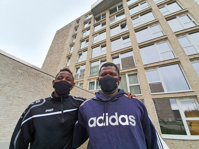 s:101:"Wisdorne Affizie (re.) und sein Sohn Claudio vor einem Übergangswohnheim für Flüchtlinge in Bremen";