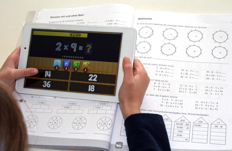 s:55:"Schülerin mit Tablet, auf dem eine Lernsoftware läuft";