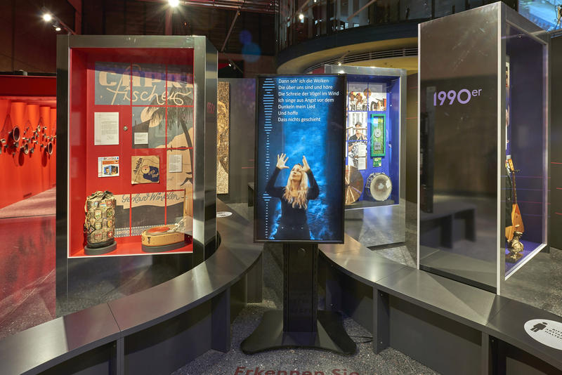 s:88:"Gebärdendolmetscherin in der Ausstellung "Hits & Hymnen" im Bonner Haus der Geschichte.";