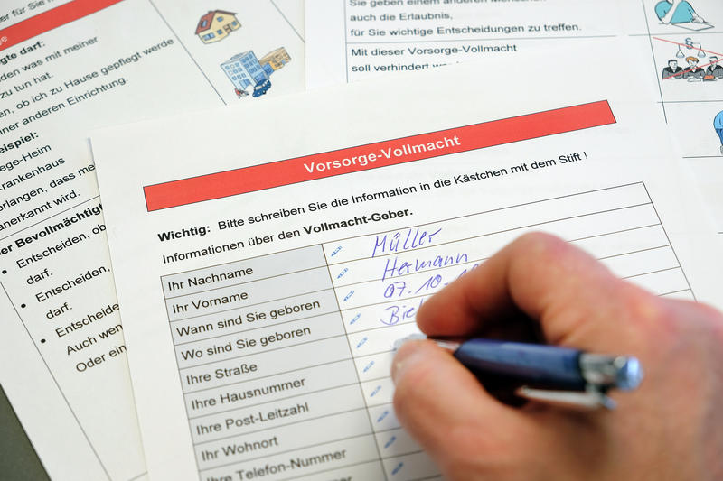 s:55:"Ein Mann füllt ein Formular zur Vorsorgevollmacht aus.";