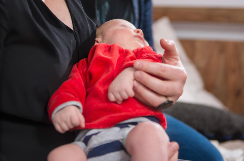 s:34:"Eine Mutter hält ein Baby im Arm.";