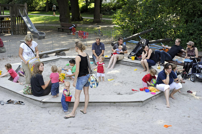 s:43:"Eltern mit ihren Kindern auf dem Spielplatz";