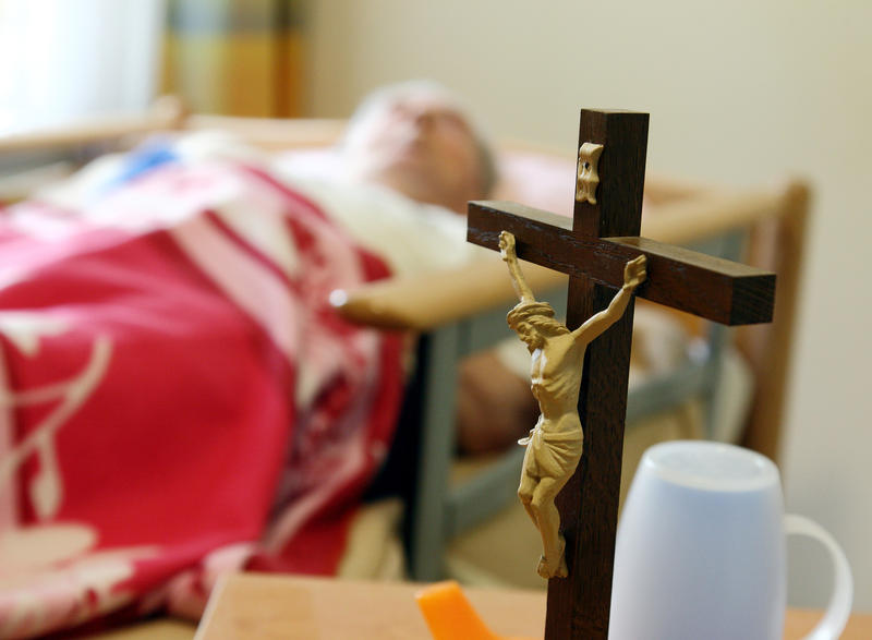 s:52:"Kruzifix auf dem Nachttisch eines Altenheim-Bewohner";