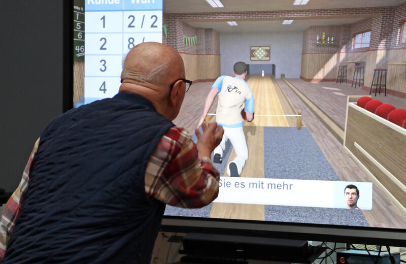 s:39:"Senior beim Kegeln an der Spielekonsole";