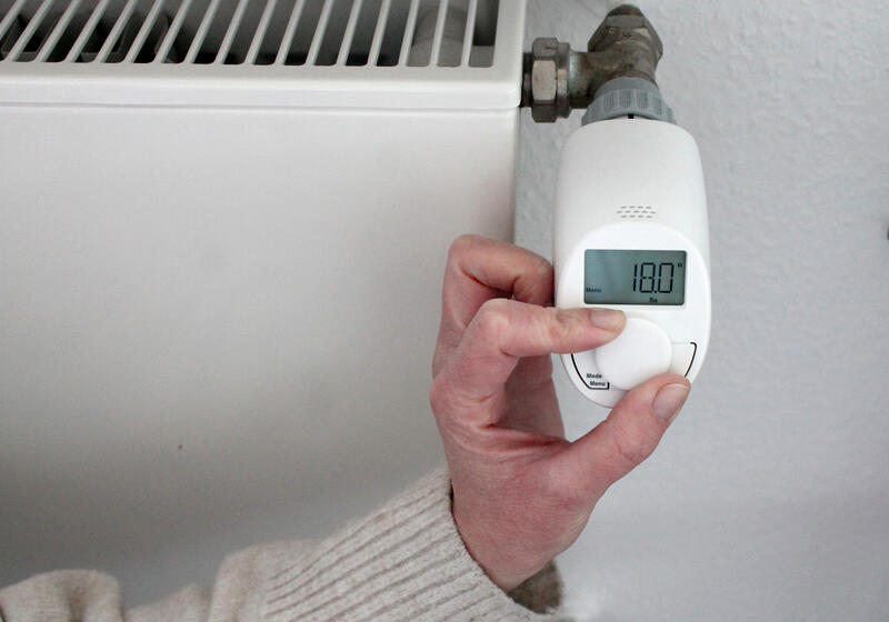 s:88:"Eine Frau stellt die Heizung in ihrer Wohnung auf 18 Grad Celsius, um Energie zu sparen.";