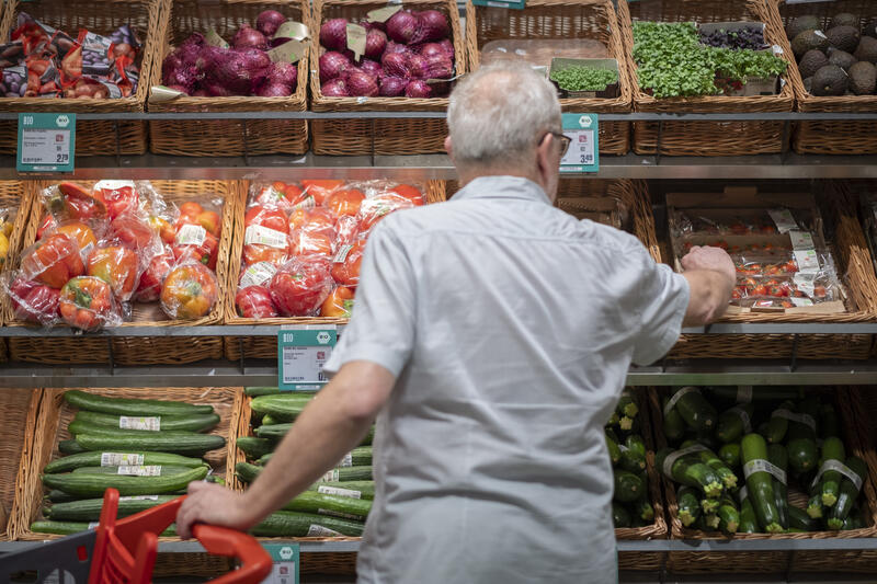 s:38:"Mann am Gemüsestand eines Discounters";