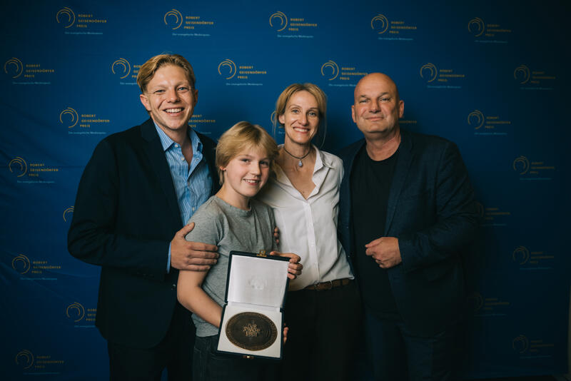 s:128:"Preisträger: Nicole Armbruster (Autorin), Marc Brummund (Autor/Regisseur), Leonard Kunz (Schauspieler, li.) und Camille Moltzen";