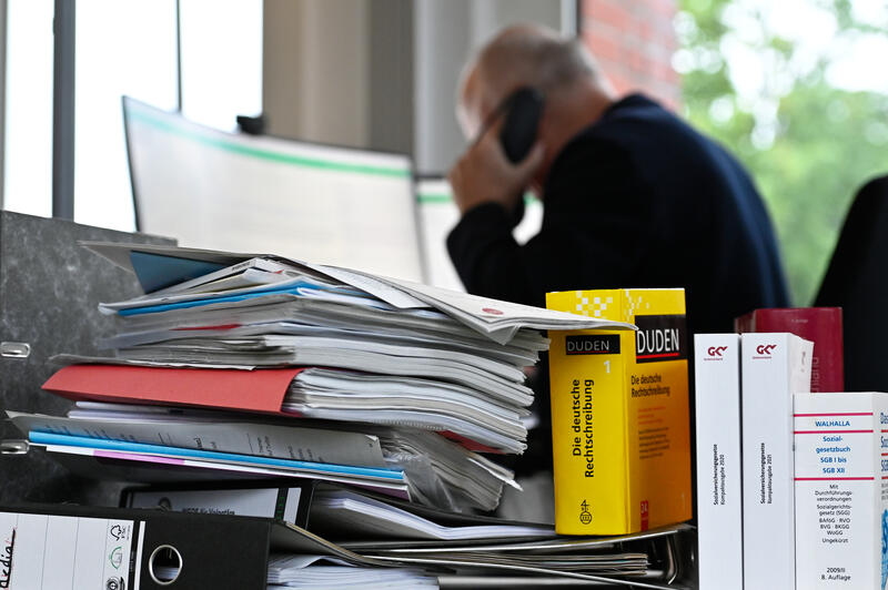 s:50:"Arbeitsplatz mit Ablagen und Büchern (Themenfoto)";