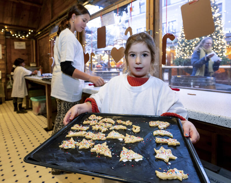 s:105:"Luise präsentiert ihre Weihnachtsplätzchen in der Weihnachtsbäckerei auf dem Weihnachtsmarkt in Speyer";