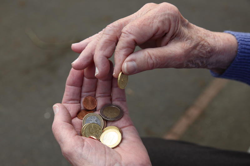 s:30:"Ein Rentnerin zählt ihr Geld.";