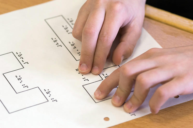 s:68:"Mathematikunterricht, ein Schüler liest Aufgaben in Brailleschrift.";