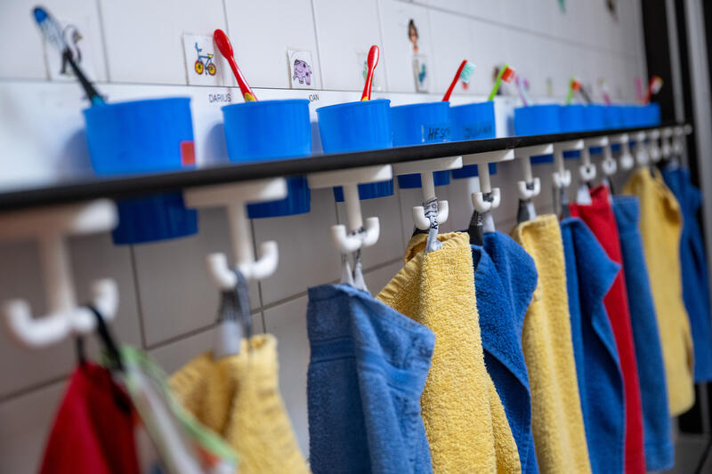 s:56:"Handtücher und Zahnbürsten in einer Kindertagesstätte";