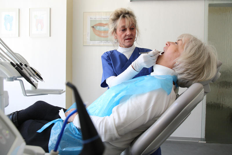 s:54:"Eine Zahnärztin behandelt eine Patientin (Themenfoto)";