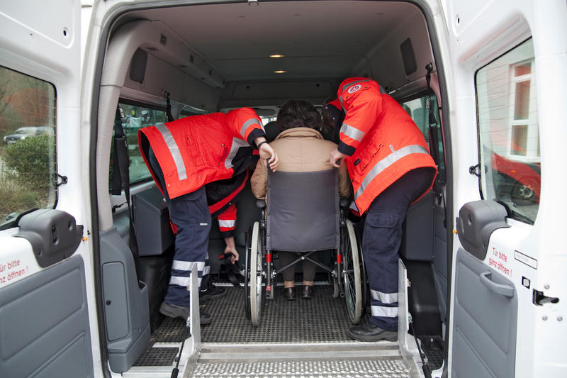 s:114:"Zwei Bufdies vom Fahrdienst der Johanniter-Unfallhilfe in Wiehl bringen eine Seniorin zur Tagespflege (Archivbild)";