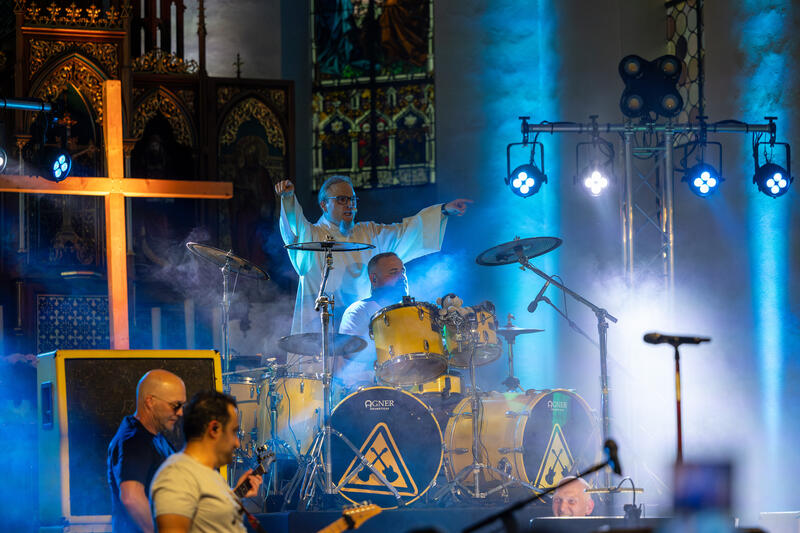 s:99:"Pastoralreferent Mathias Fuchs (hinten) bei einem Heavy-Metal-Gottesdiens mit der Band "Metal Godz"";