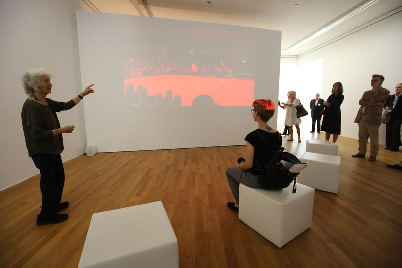 s:169:"Die US-amerikanische Künstlerin Simone Forti (i.l) erläutert im Kunstmuseum Bonn eine Video-Performance ihrer Ausstellung "Simone Forti - sound move" (Archivbild 2016)";
