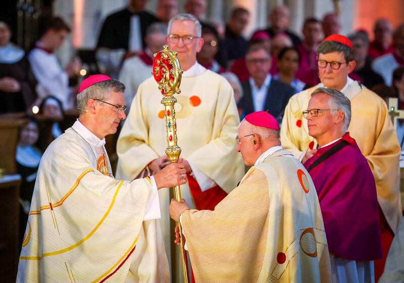 s:118:"Der neue Münsteraner Bischof Heiner Wilmer (links) erhält den Bischofsstab von seinem Vorgänger Felix Genn (rechts)";