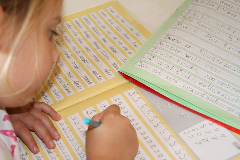 s:36:"Mädchen schreibt in Schreibschrift.";