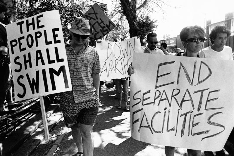 s:82:"Bürger von Yeoville (Südafrika) demonstrieren im Jahr 1989 gegen Rassentrennung.";