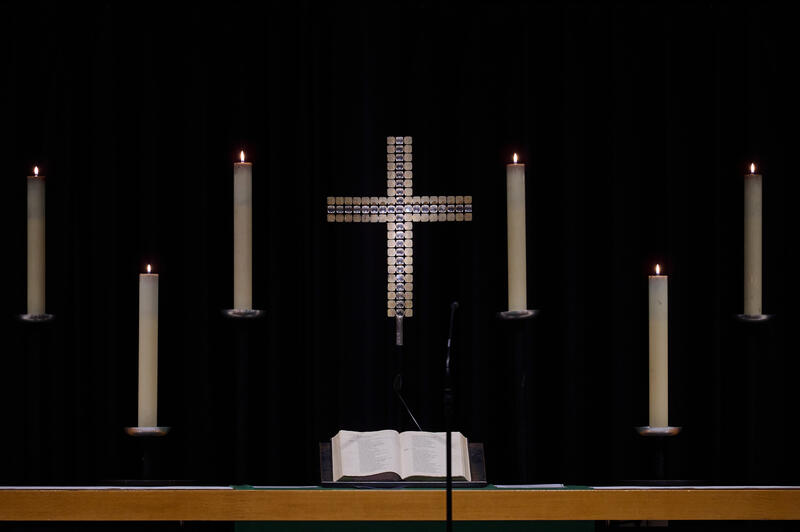 s:50:"Altar mit Kreuz, Kerzen und aufgeschlagener Bibel.";
