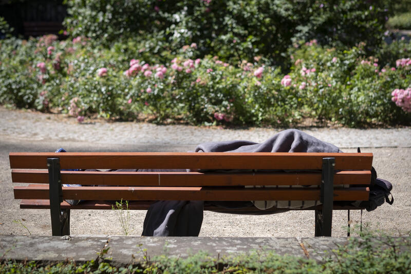 s:30:"Obdachloser auf einer Parkbank";