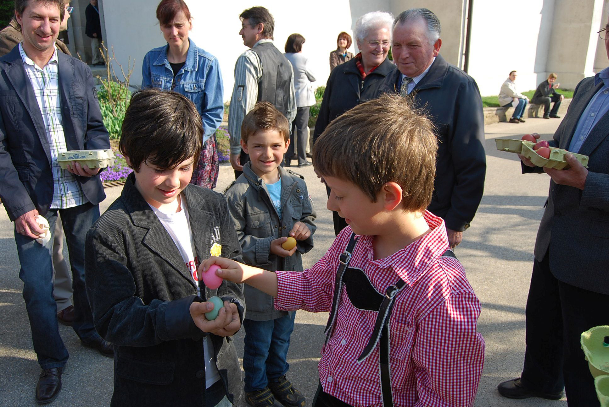 Kinder schlagen hartgekochte Eier aneinander.